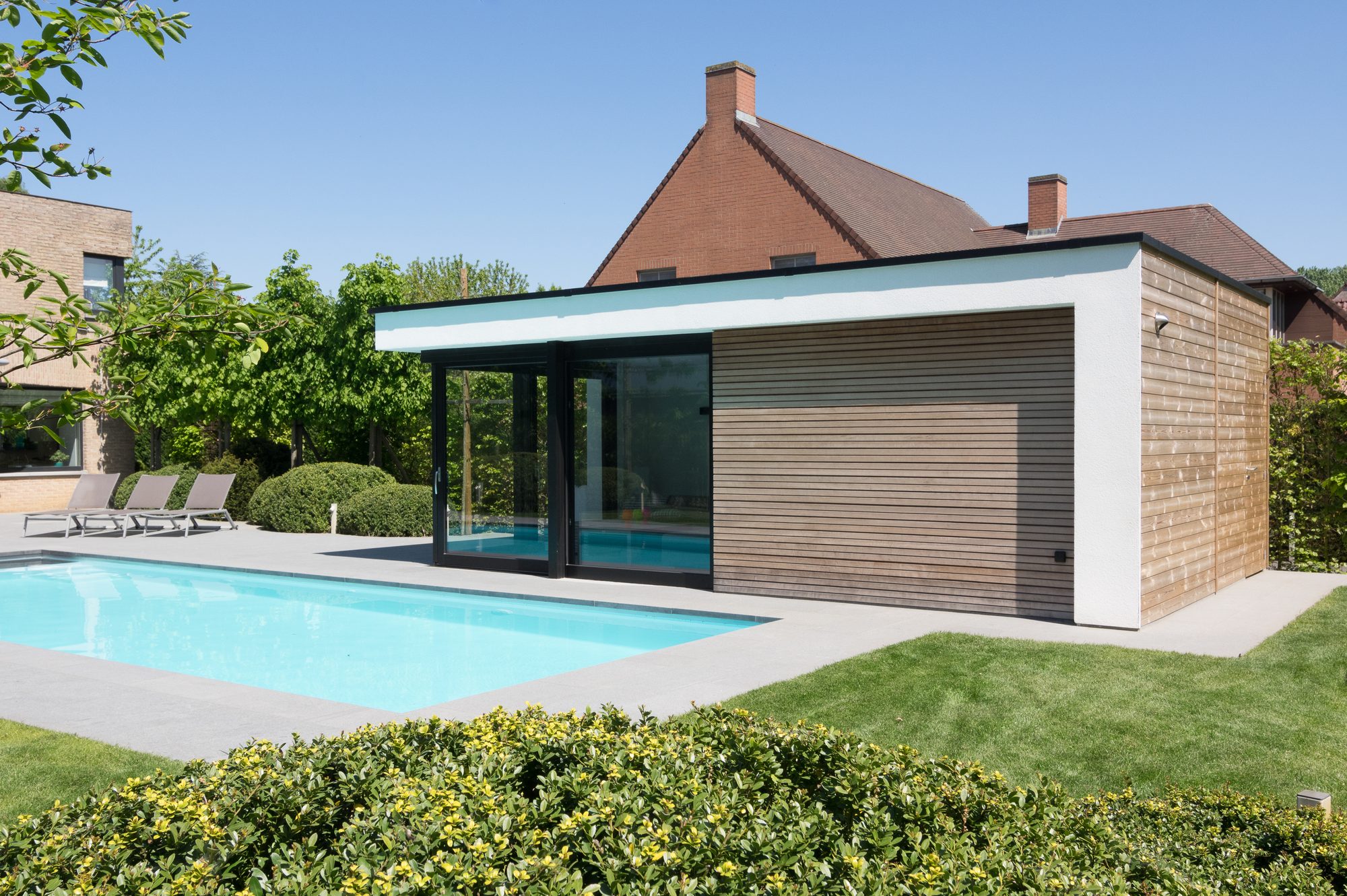 Poolhouse in witte crepi met wand in moabi en achterwand in dennehout