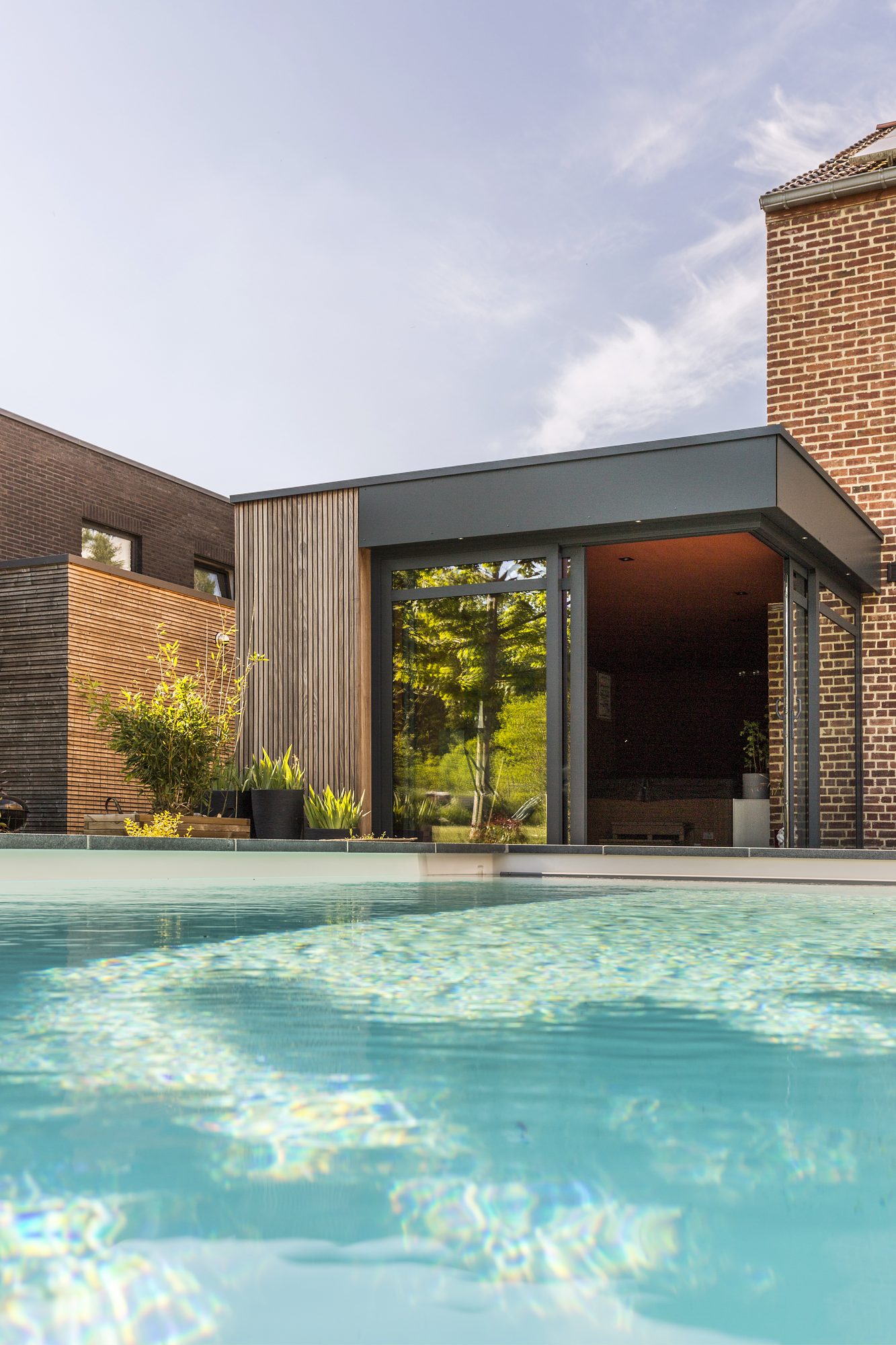 Annexe moderne avec fenêtres en Aluminium, Bandeau de Toiture en Trespa et lattes de finition en Afrormosia