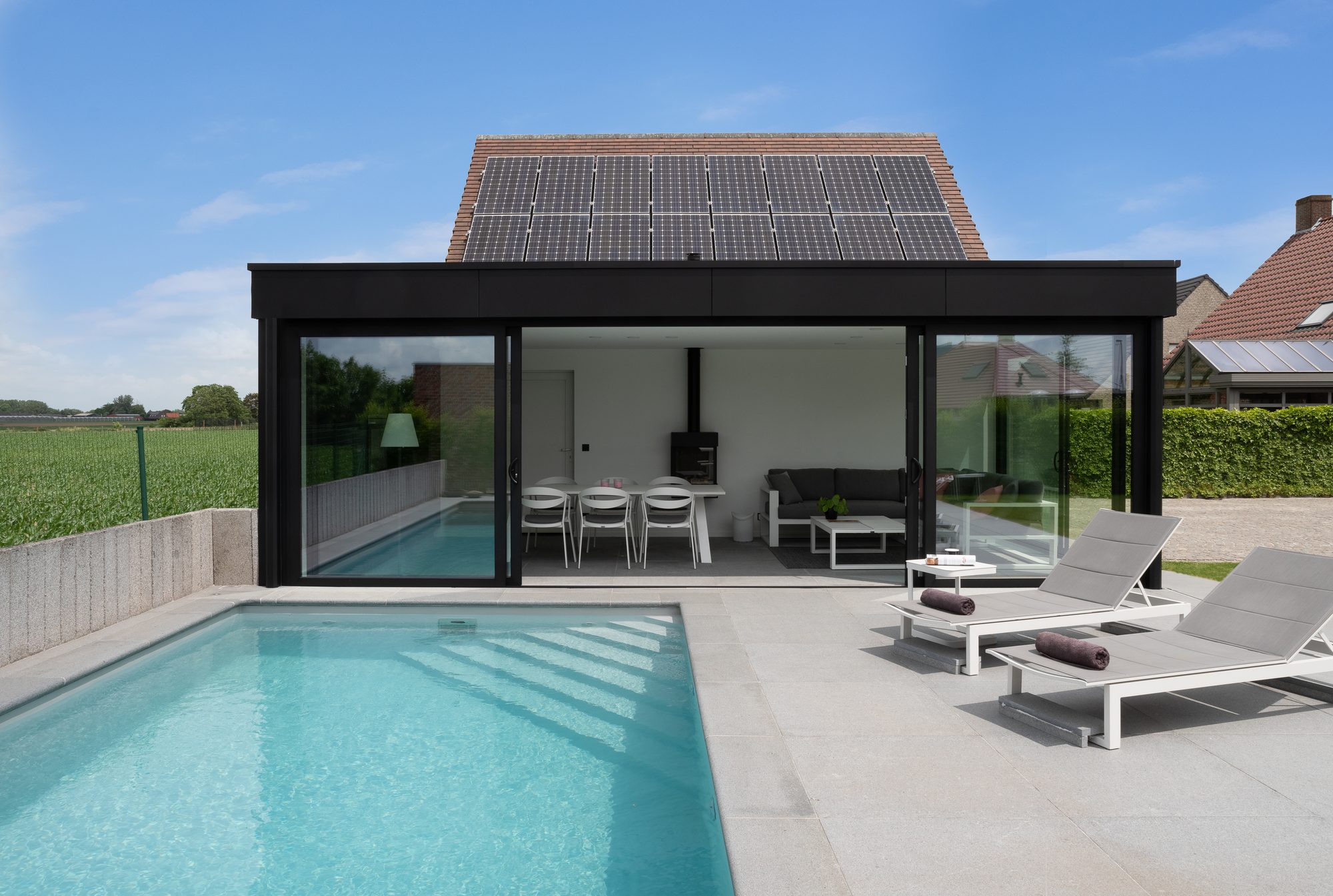 Aangebouwde poolhouse met grote schuiframen