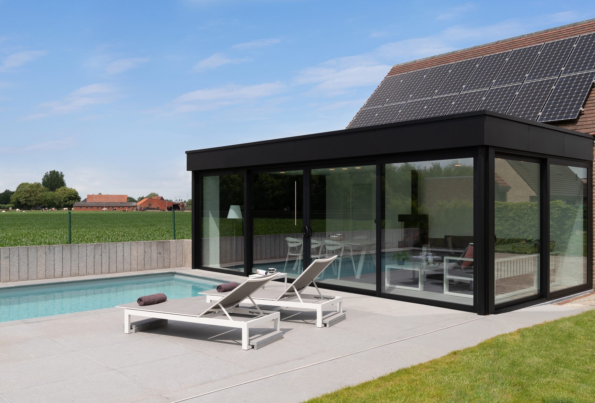Poolhouse met zwarte gelijmde trespa en aluminium ramen