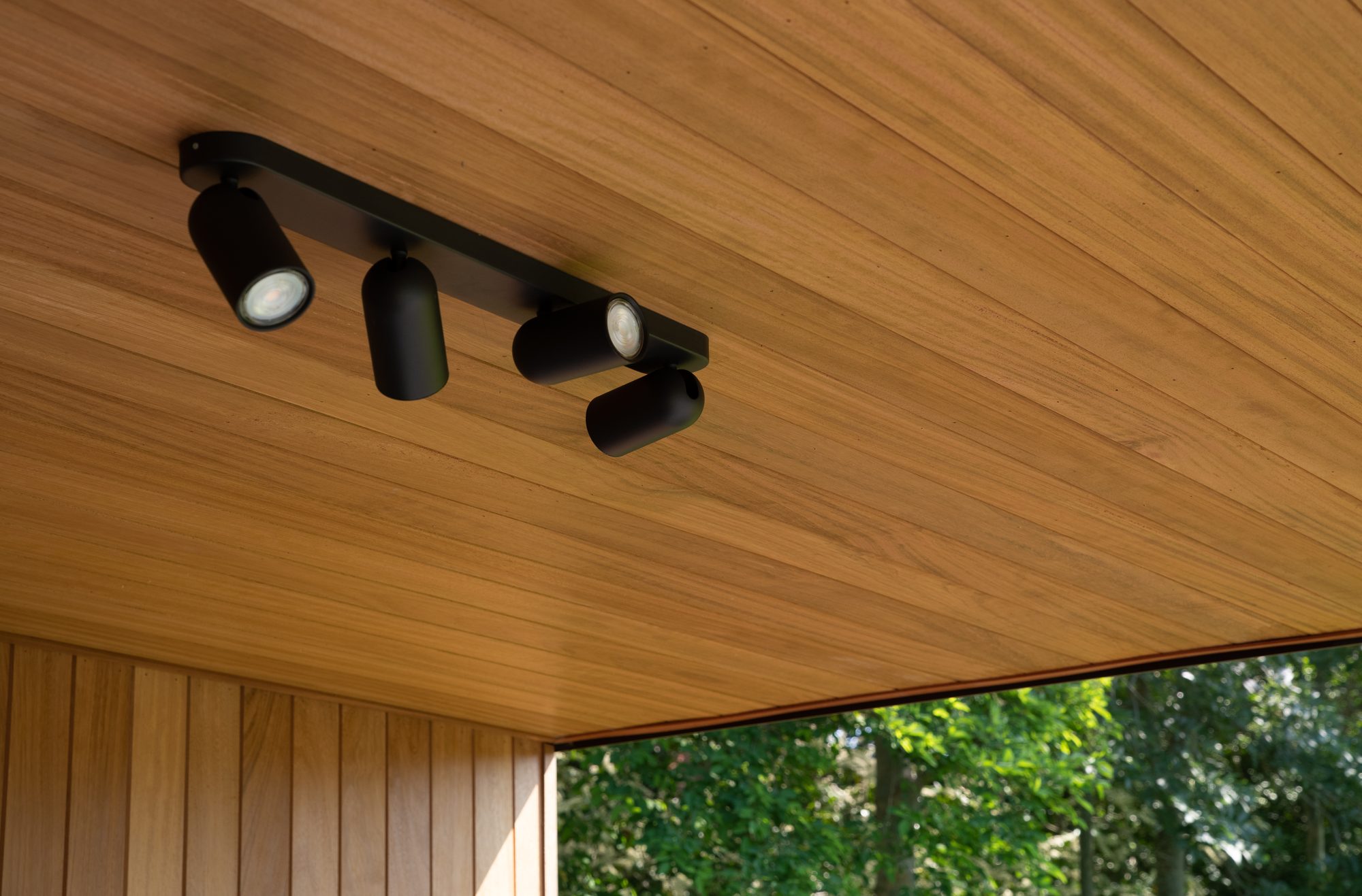Verlichting loungehoek poolhouse met iroko houten plafond