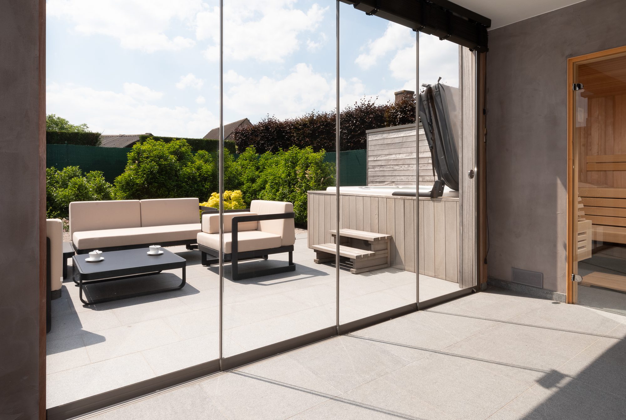 Interieur poolhouse met sauna, jacuzzi en schuiframen