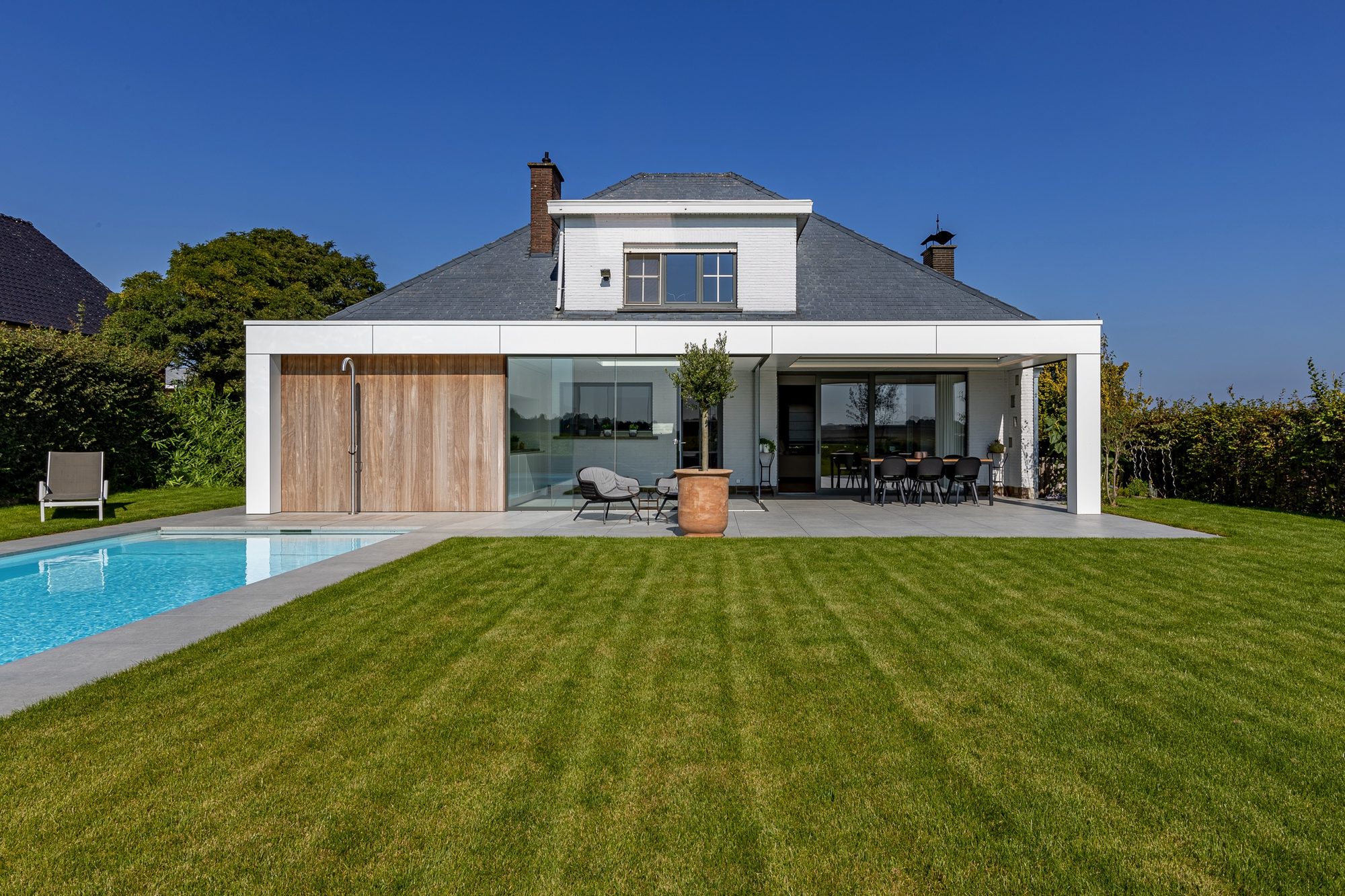 Pool house adossé avec débarras, cuisine extérieur et terrasse couverte