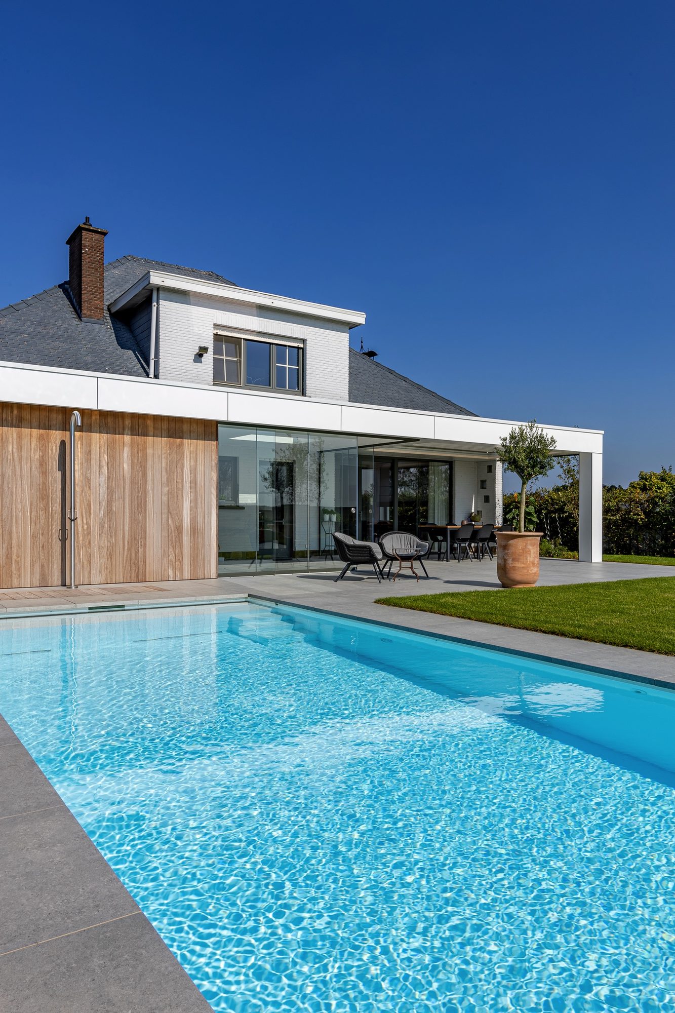 Pool house adossé moderne en Trespa blanc avec paroi en Iroko