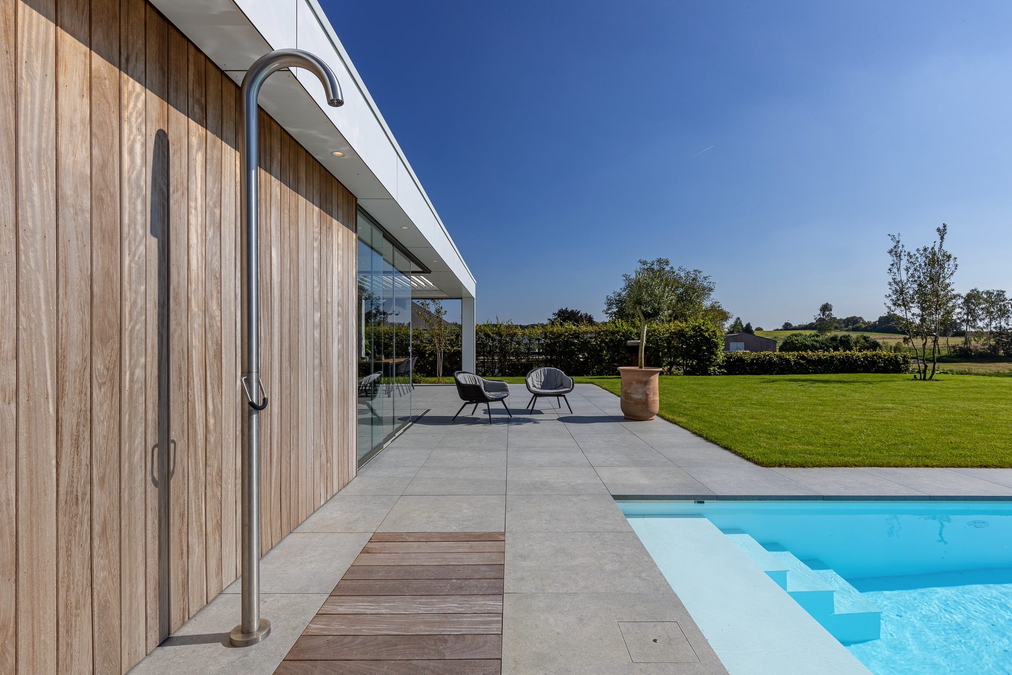 Pool house moderne avec bandeau en Trespa et paroi en Iroko