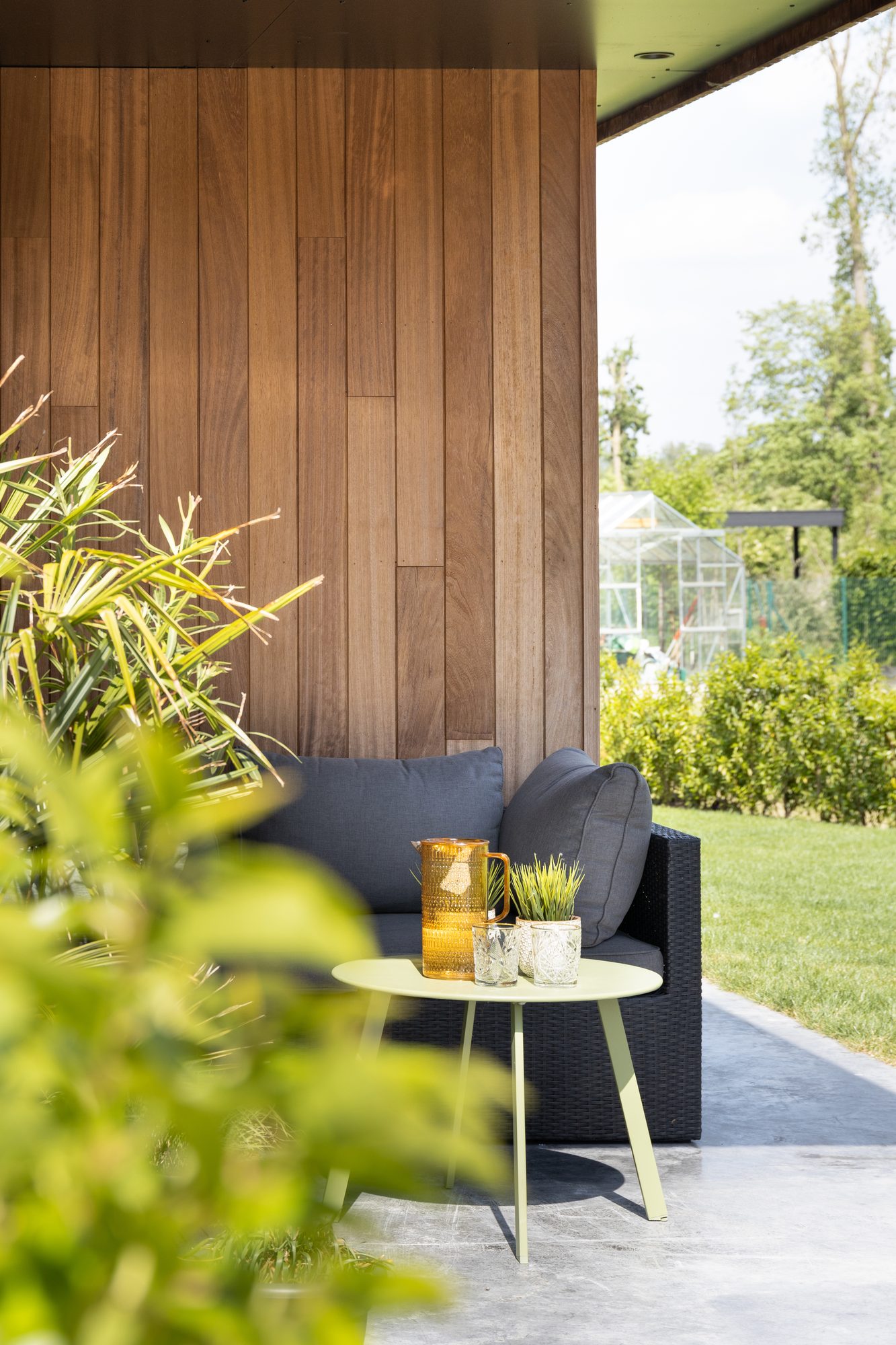 Zithoek onder oversteek tuinhuis