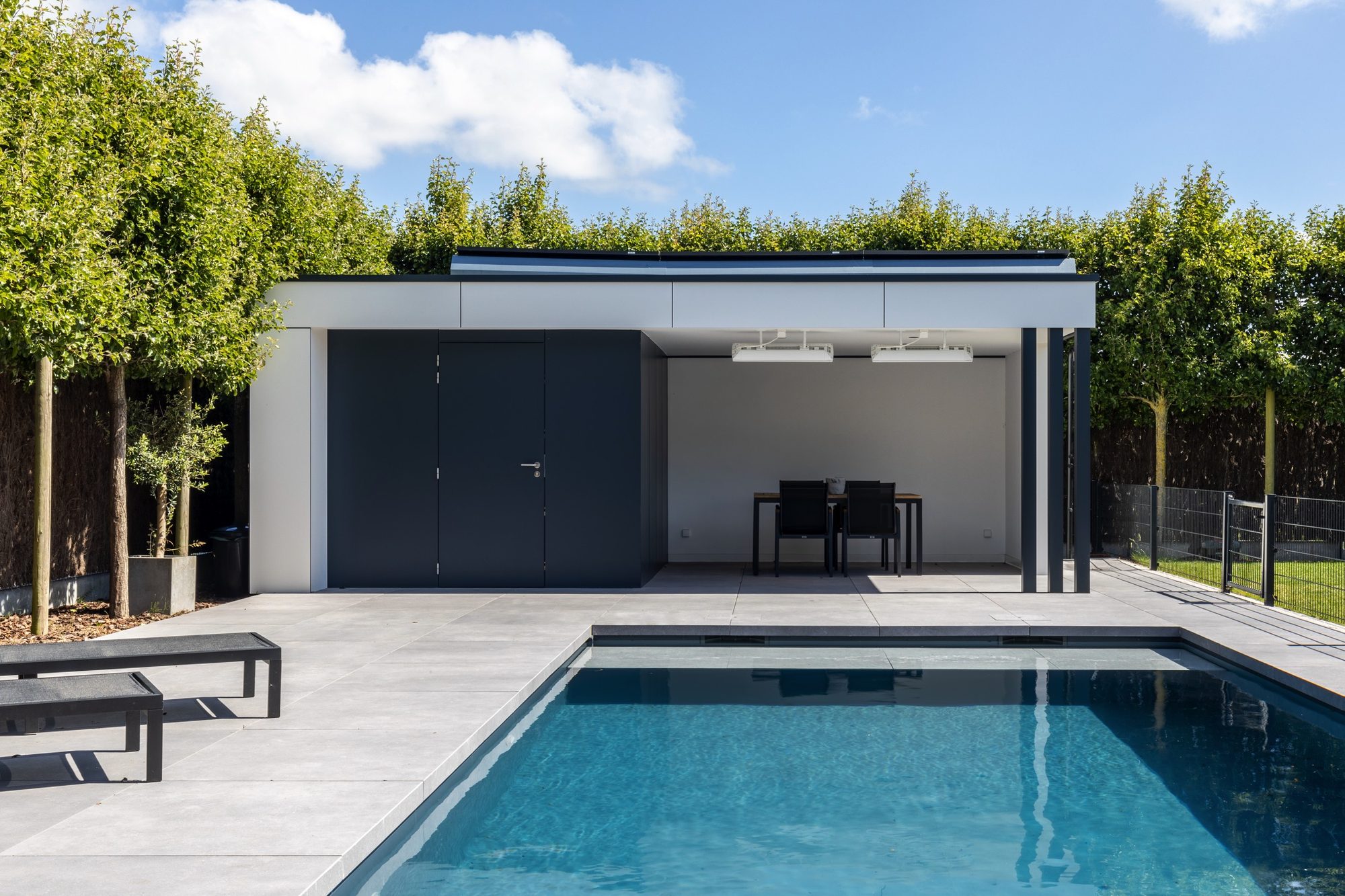 Witte poolhouse met grijze berging