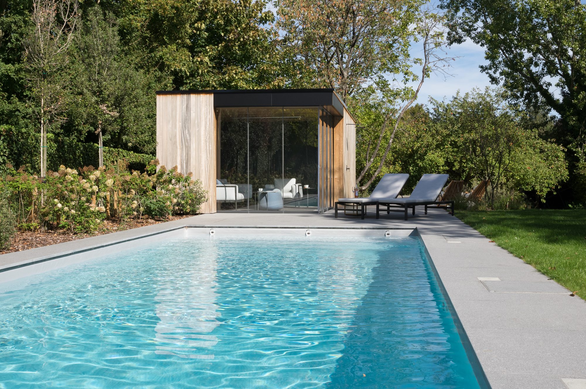Abri de piscine en padouk avec Trespa et Sunflex fenêtres coulissantes