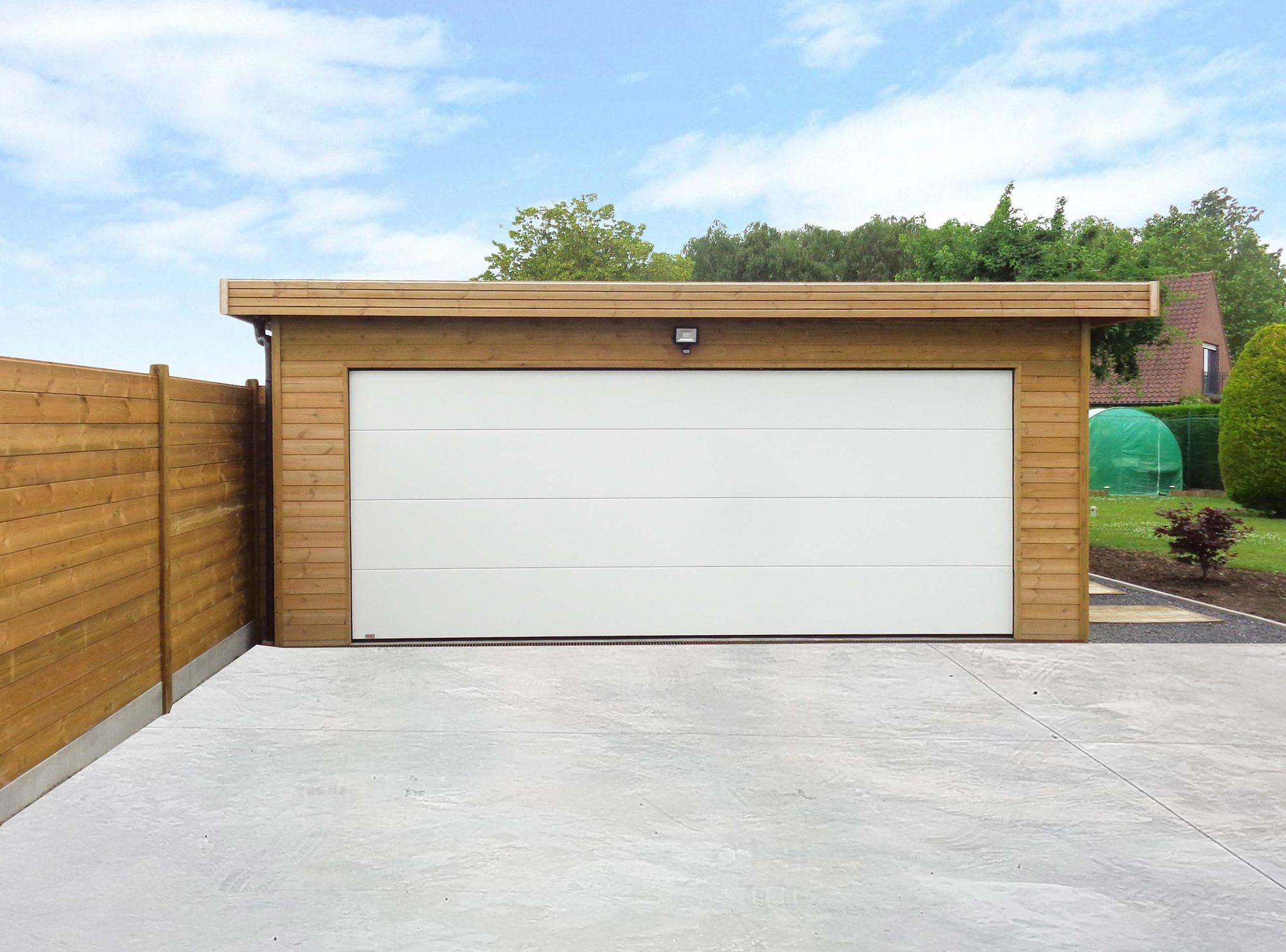 Garage double en bois avec porte sectionnelle blanche