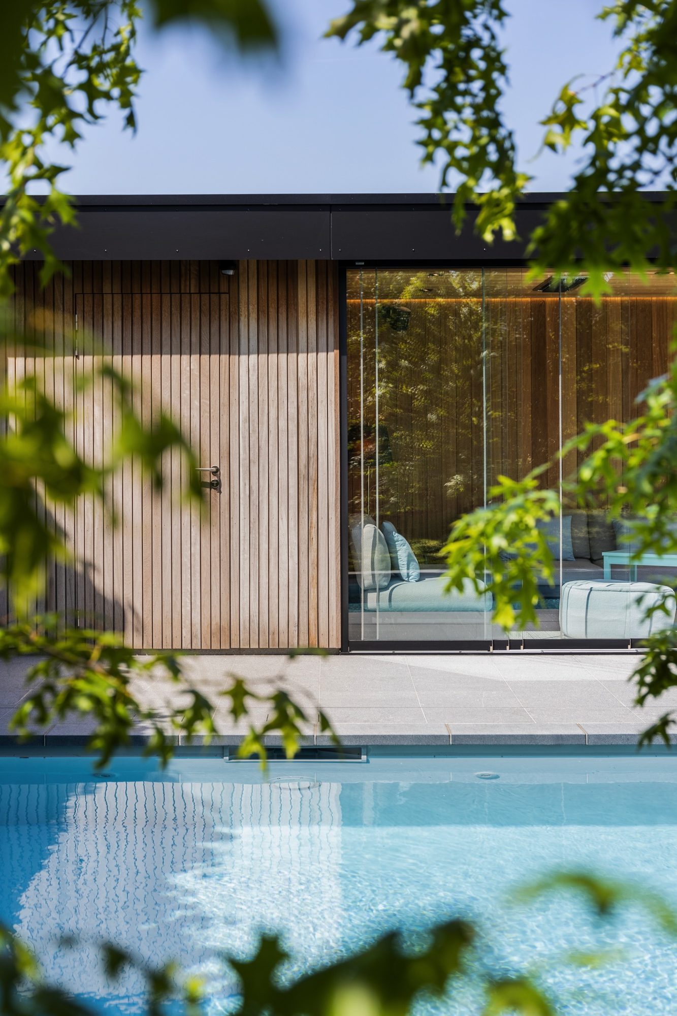 Moderne poolhouse met hout en Trespa
