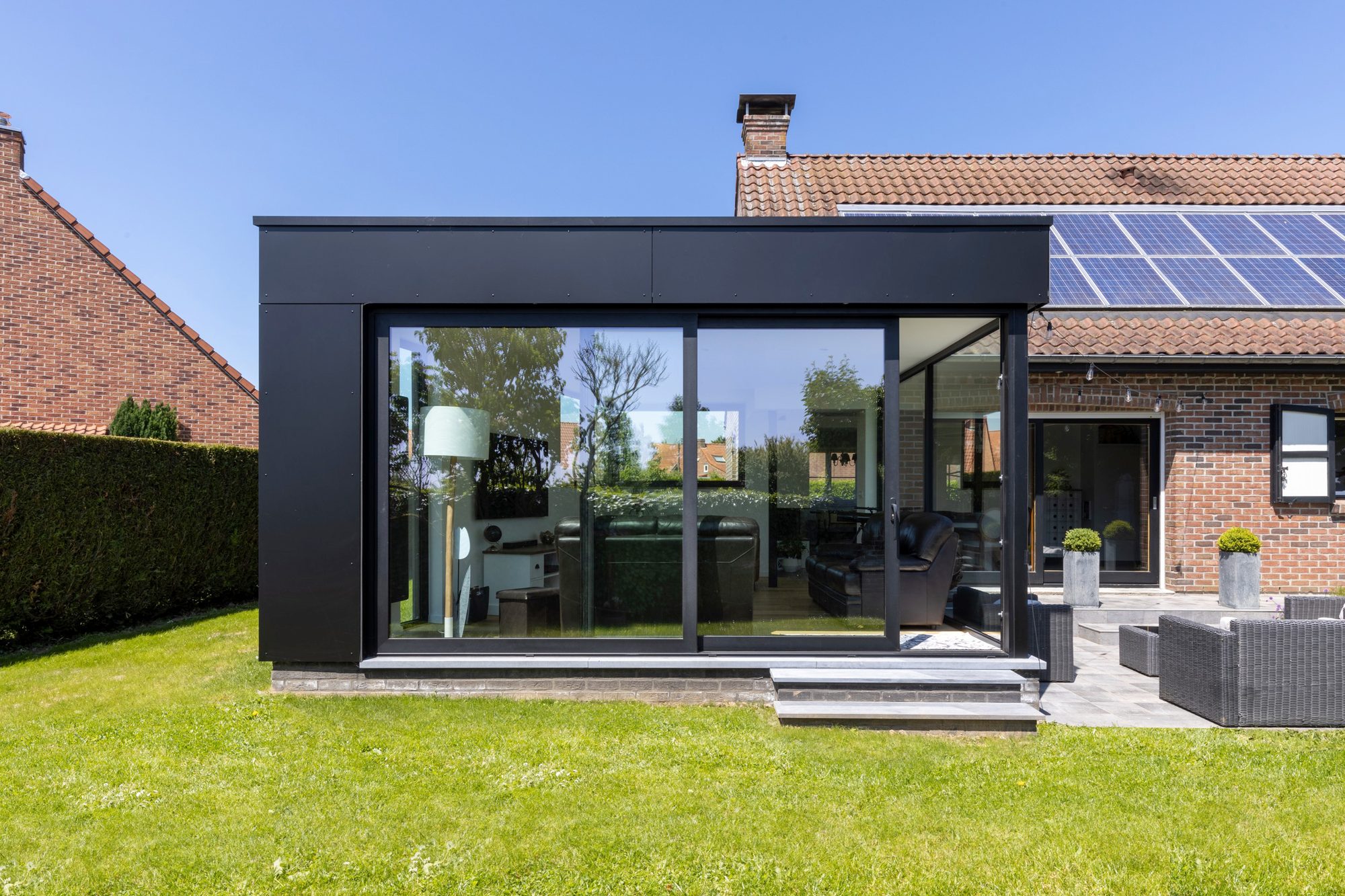 Extension de maison moderne en Trespa avec grandes fenêtres