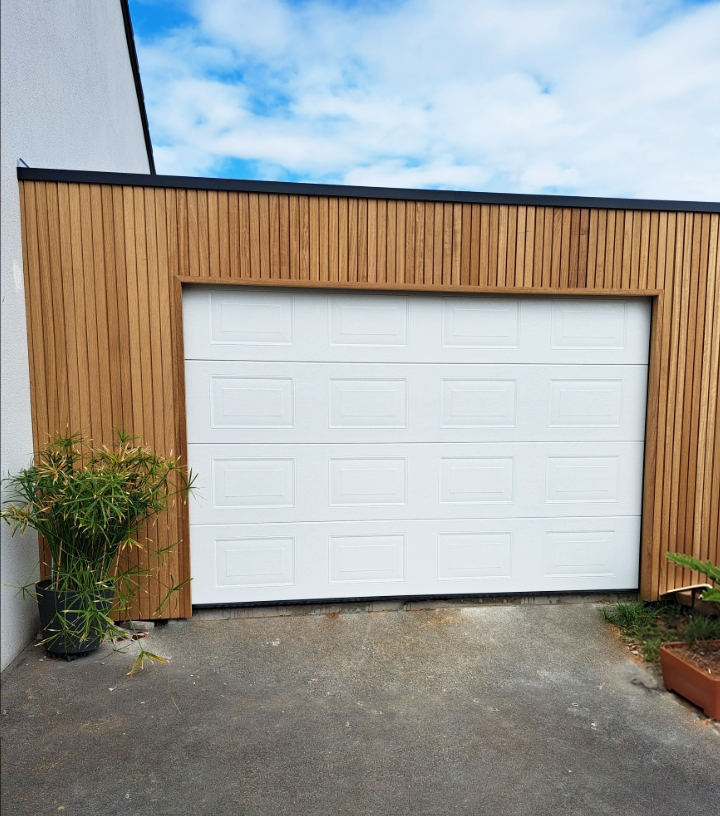 Aangebouwde houten garage met sectioneelpoort