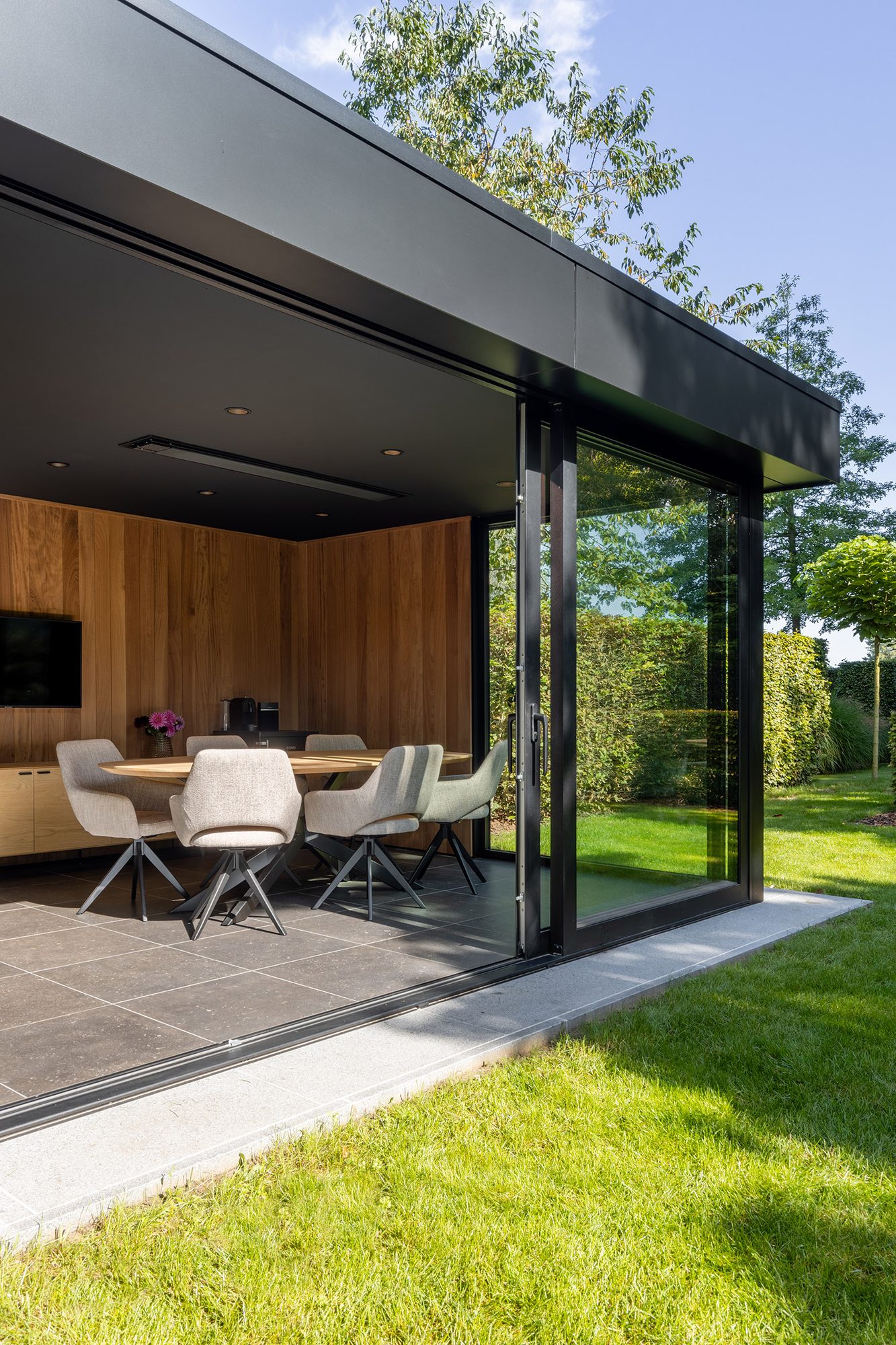 Chambre de jardin en Trespa noir avec fenêtres coulissantes en aluminium
