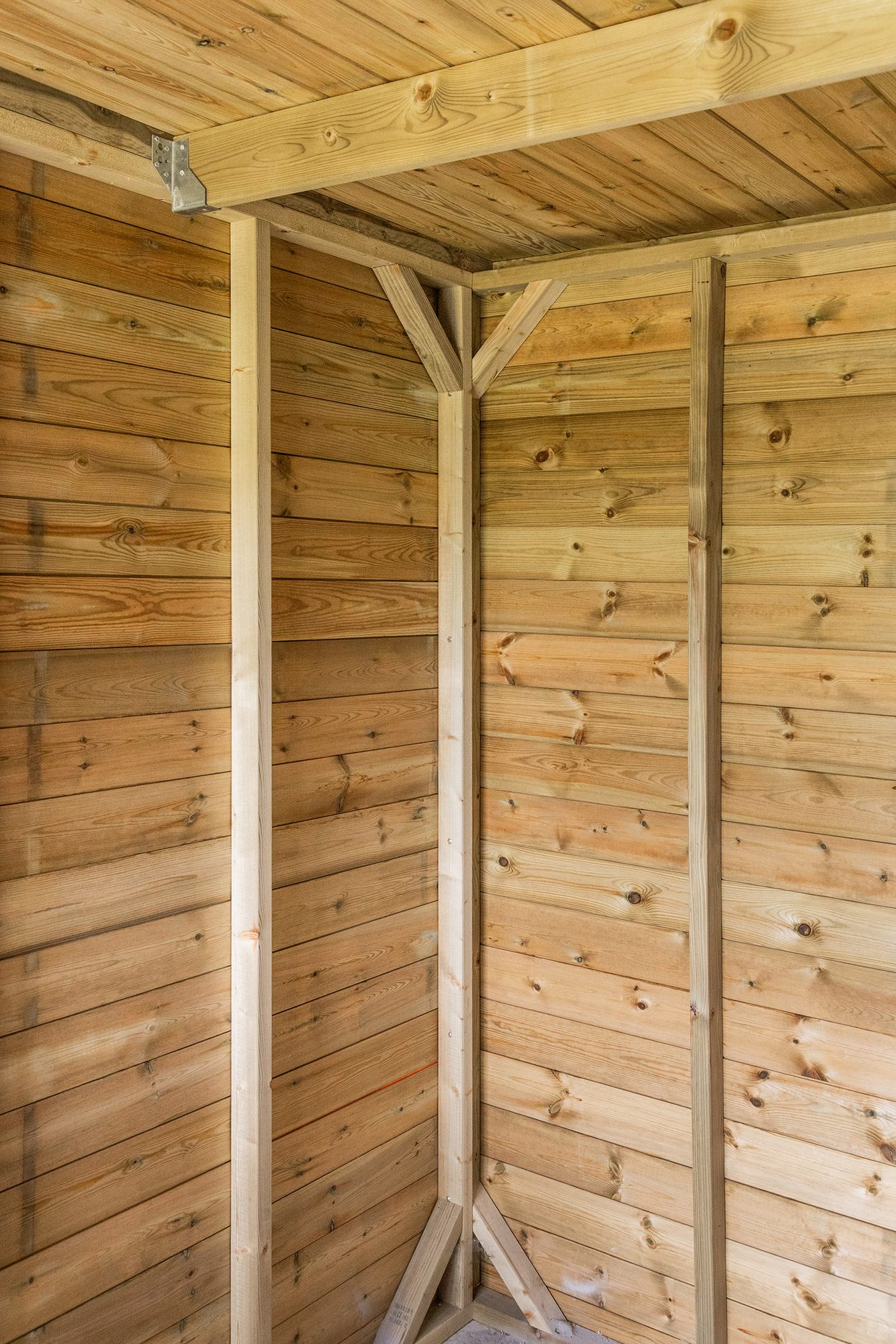Finition intérieure d'un abri de jardin en bois avec sous-toiture en bois
