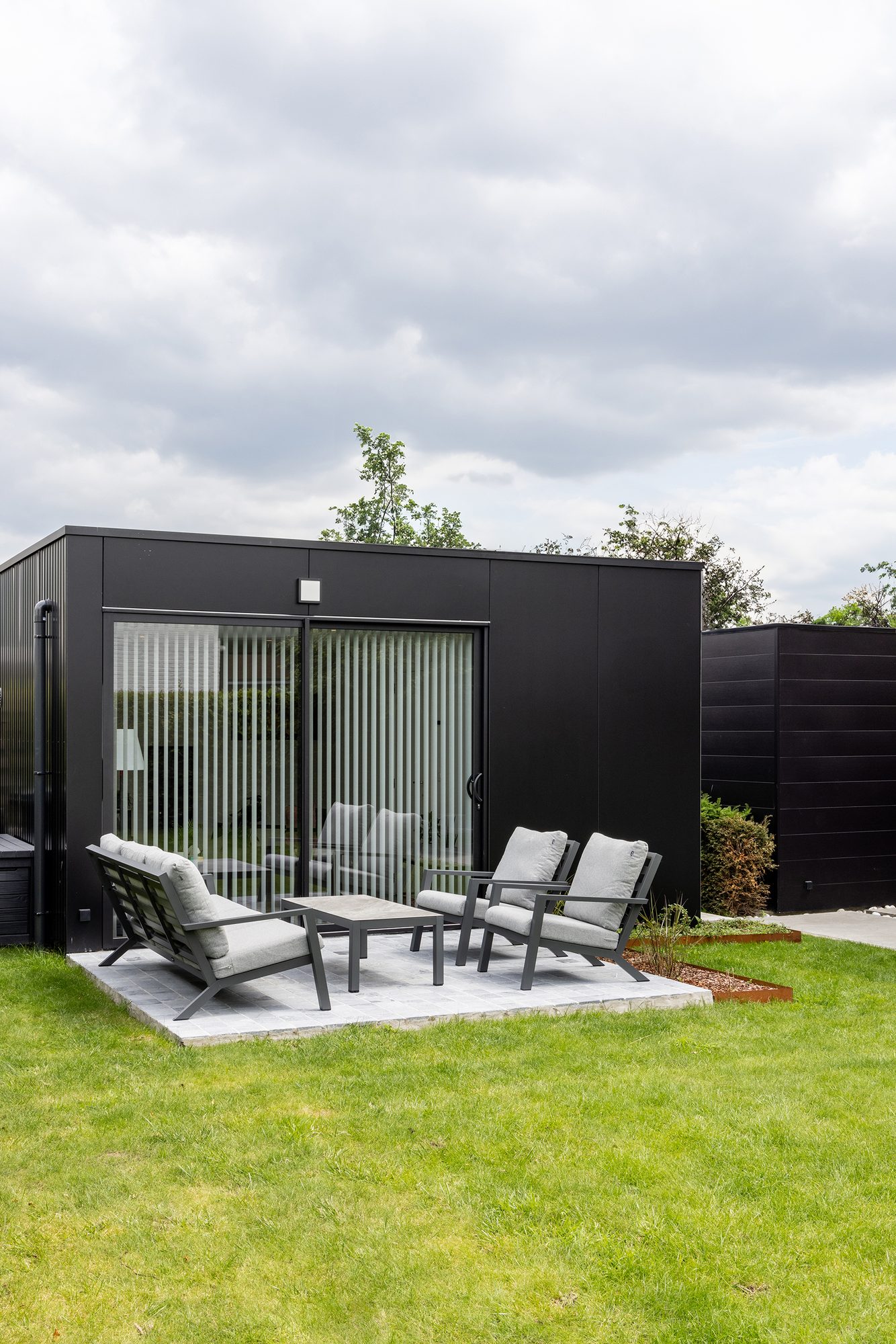 Zwart tuinkantoor met aluminium ramen