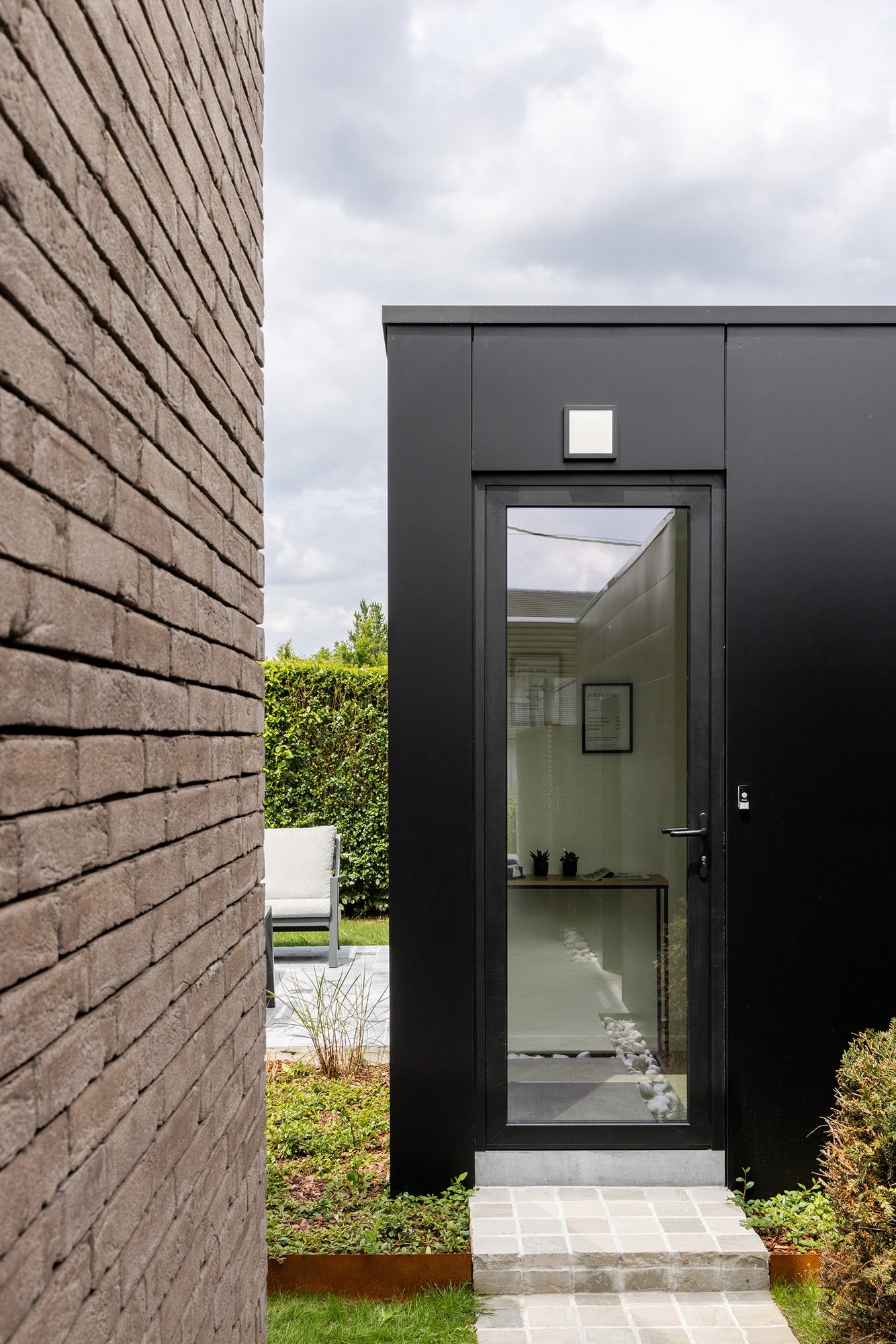 Tuinkamer met glazen deur in zwart aluminium