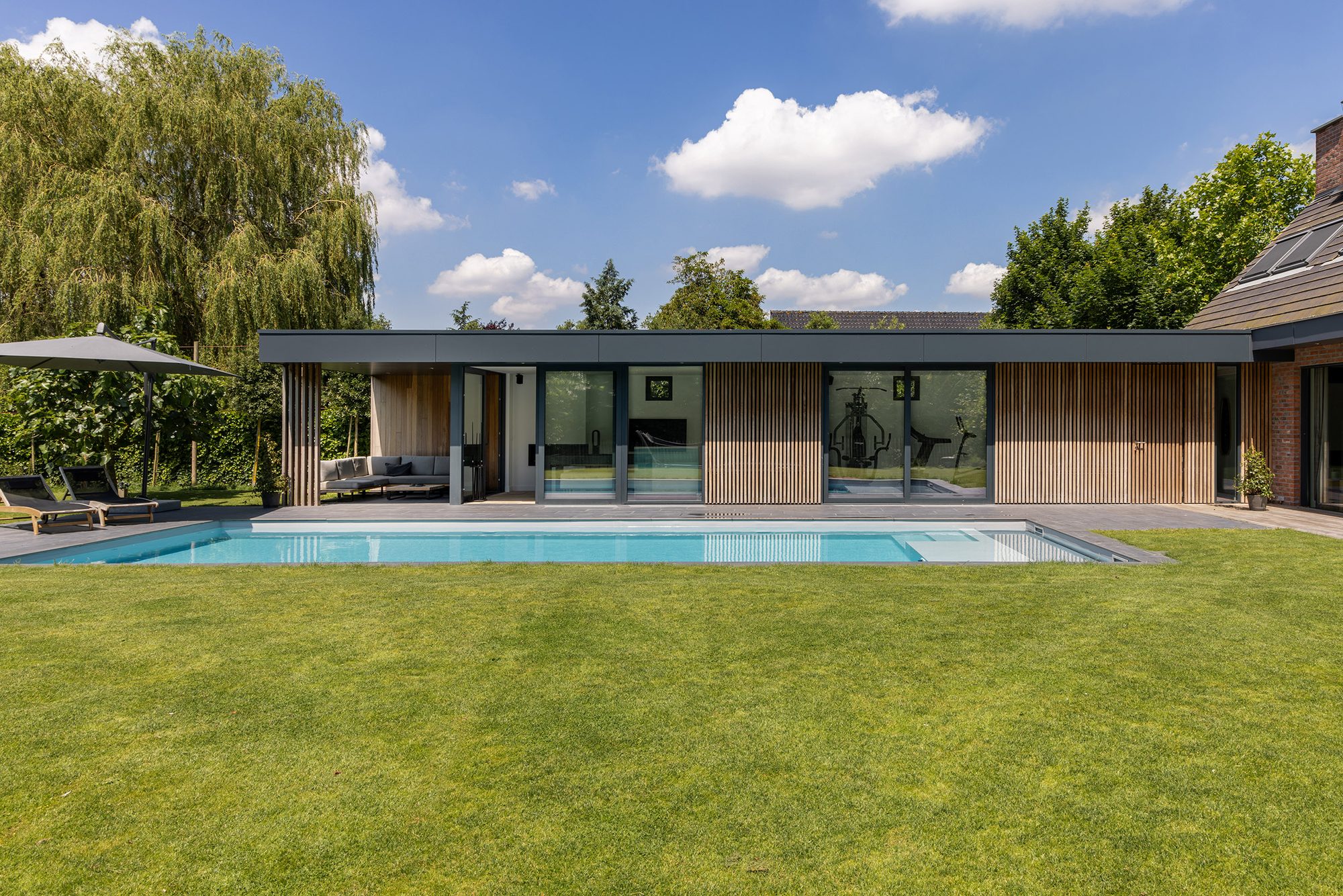 Pool house avec bois dur tropical et Trespa