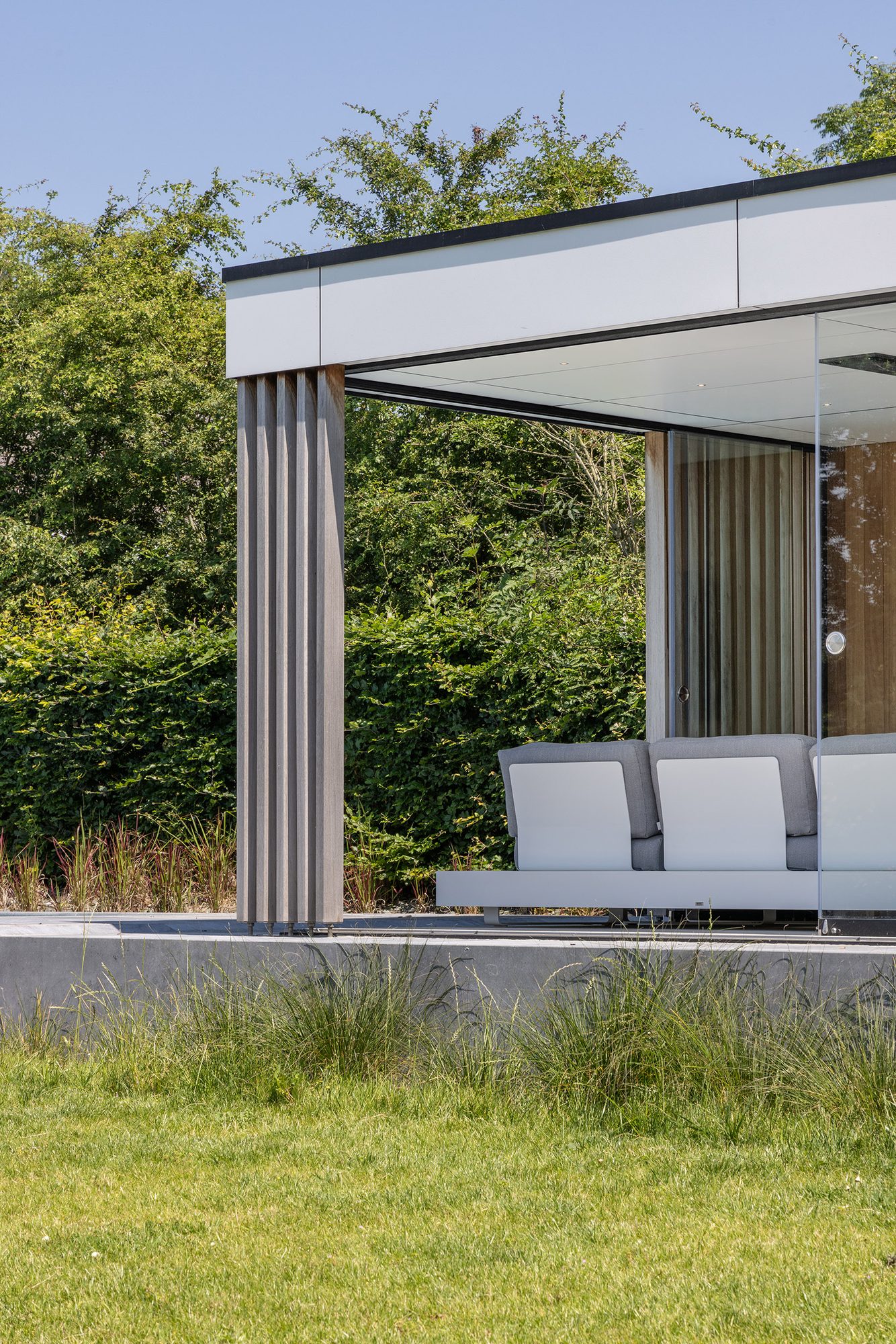 Pool house avec poteaux décoratifs en bois et bandeaux en Trespa