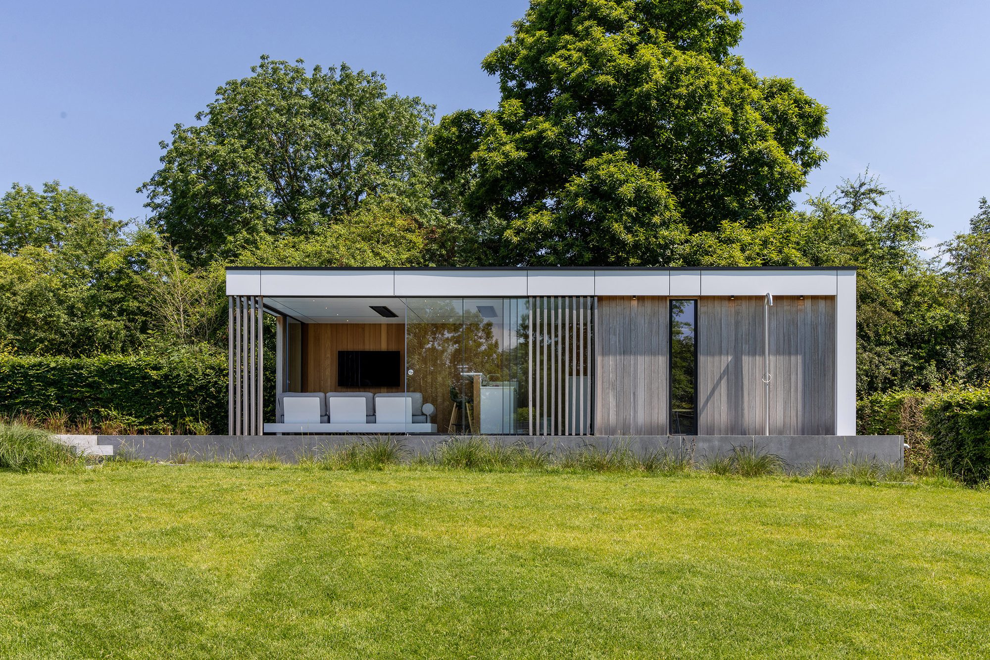 Pool house avec mur en bois iroko et bandeaux en Trespa