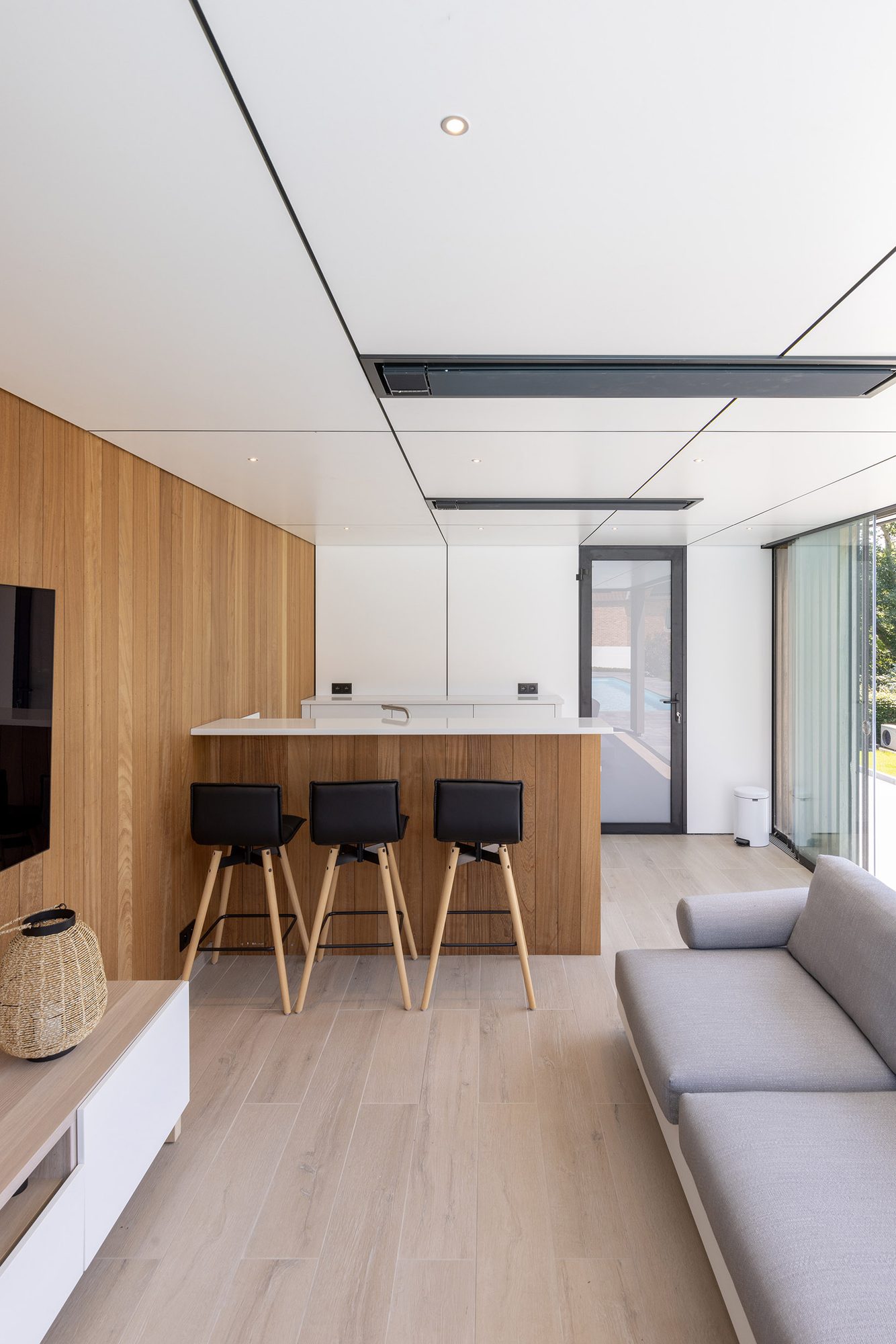 Salon pool house avec mur en bois et plafond en Trespa