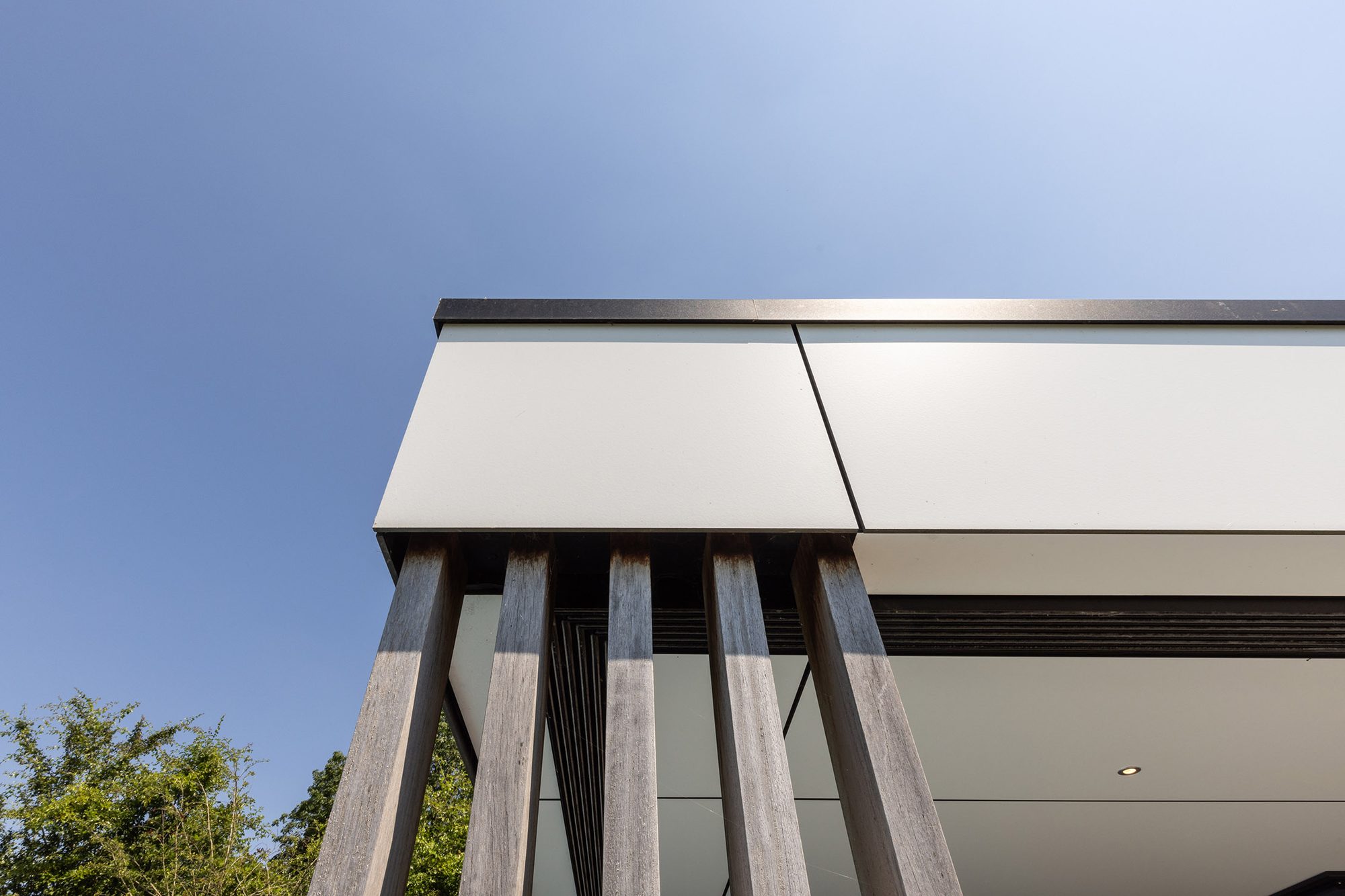 Poteaux décoratifs en Iroko et bandeau en Trespa blanc collé