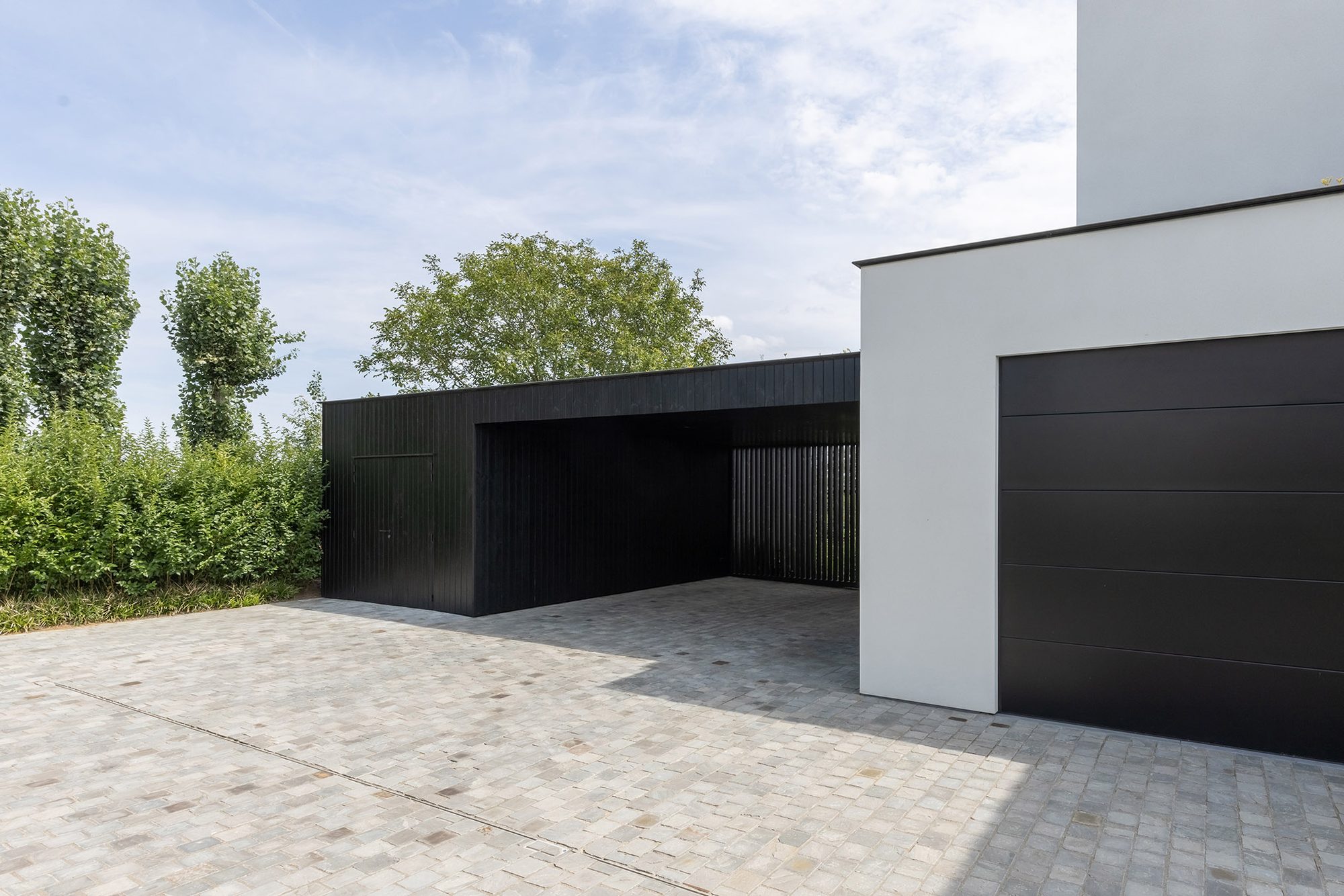 Aangebouwde carport met zwart hout