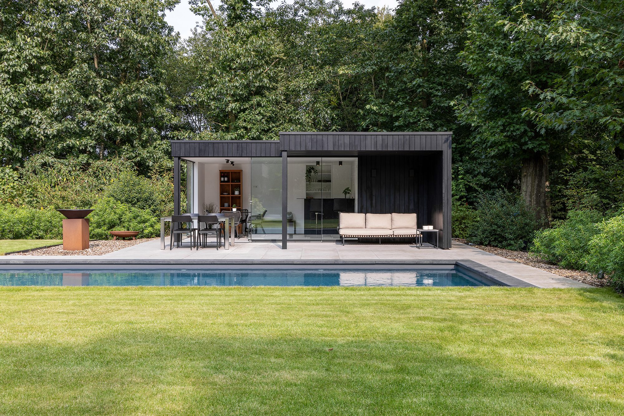 Design poolhouse bekleed met zwart gebeitst hout